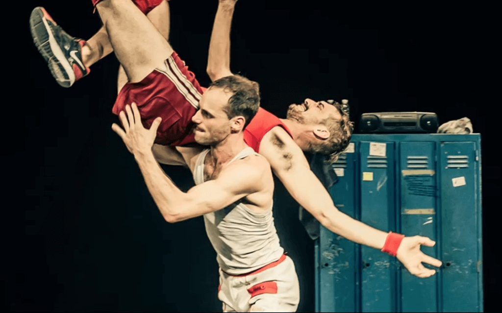 Two male wrestlers in a choreographed "body toss."