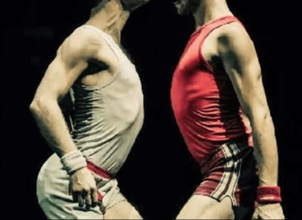 Close-quarters wrestling pose evoking intimacy and rivalry.